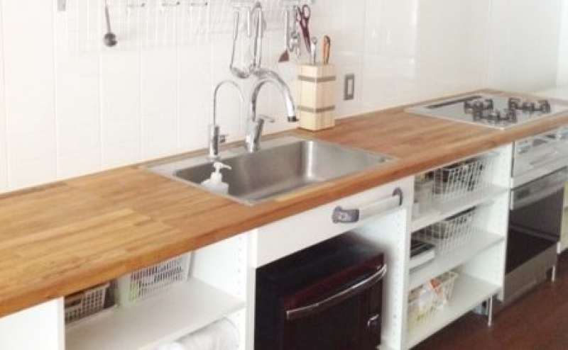 木製のキッチンカウンターです。ガスコンロとIHコンロ、ガスオーブン、電子レンジ、冷蔵庫などがそろっています。