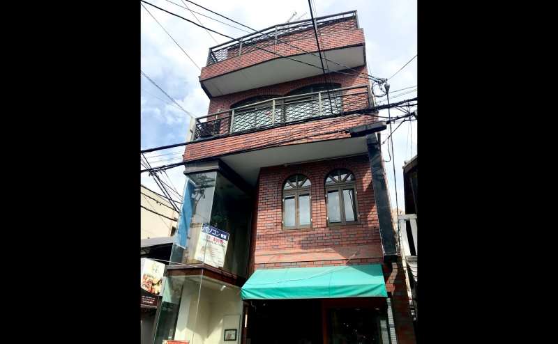 茶色のレンガの建物の2階にございます。