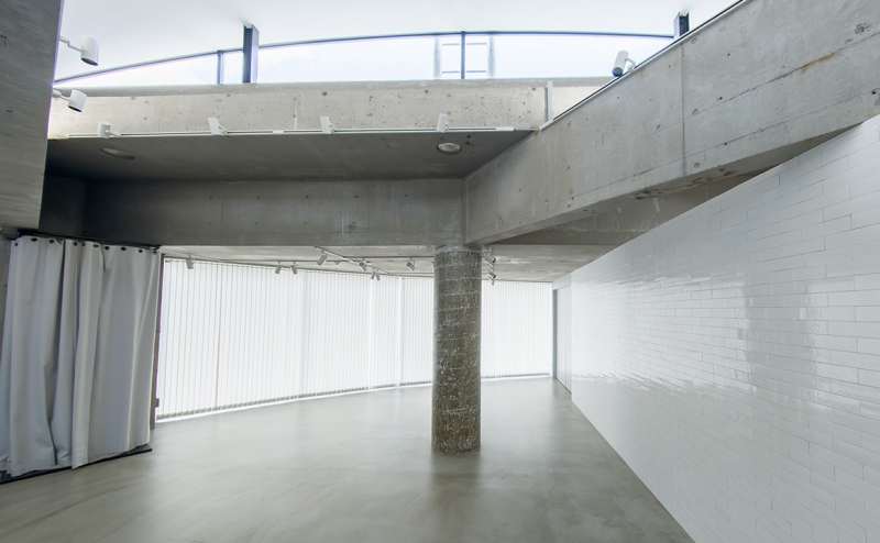 ショールームエリア｜清潔感ある白タイルと無機質なコンクリートが調和した、抜け感のあるスタイリッシュで心地よい空間