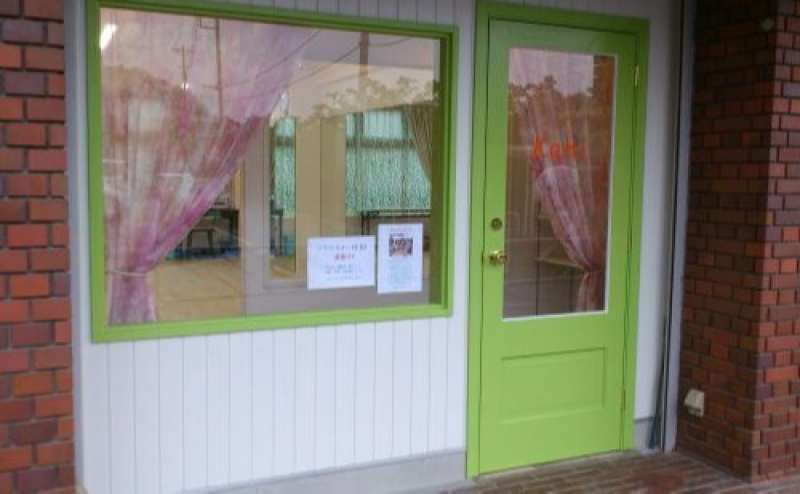 グリーンのドアとピンクのカーテンのとてもかわいいドアです