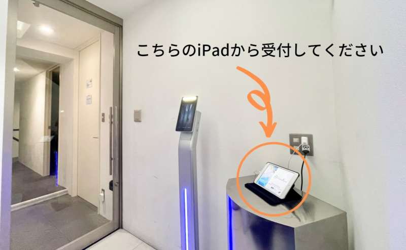 4階エレベーターホールです。 画面右のiPadにて受付を行ってください。