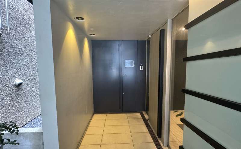 【スペースの入り口は、正面の黒い扉です。（マンションの入り口とは異なりますのでご注意ください。）】