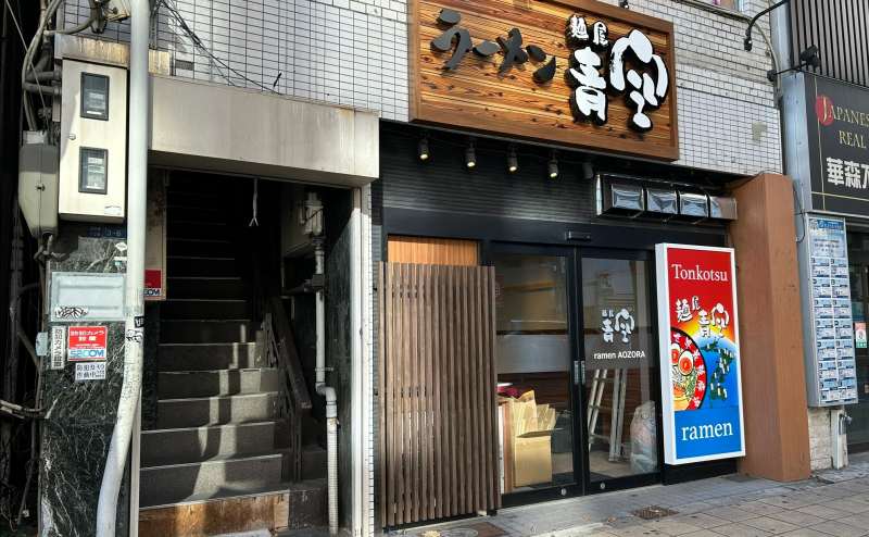 「ラーメン青空」の左にある階段で指定の部屋へお進みください。