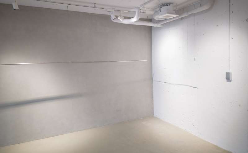 モルタル壁×モルタル床エリア｜右手側の白壁にはピクチャーレール設置