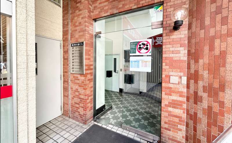 【「第二東文堂ビル」と館銘板があるガラスドアがビルの入口です】 - TIME SHARING 飯田橋 第二東文堂ビル 7Fの写真