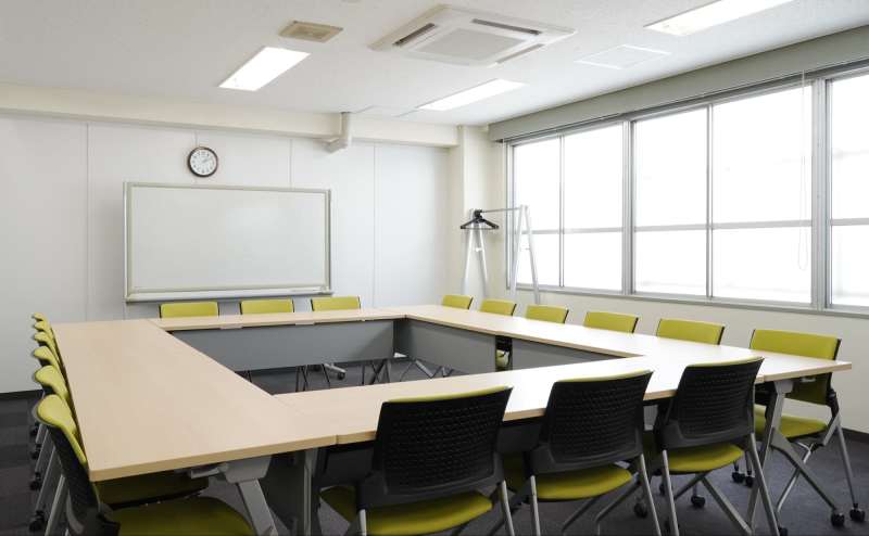 全面に広がる窓からの光で明るく開放的な会議室。セミナーや会議などにぴったりな会場です。※ロの字形式(基本レイアウト)　18名着席可能。