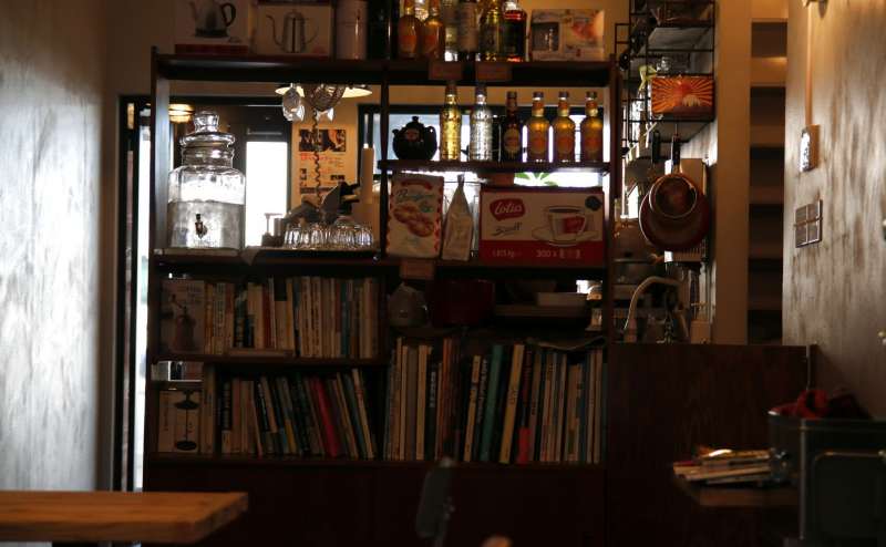 1Fカフェの室内の様子です　本棚からこぼれる光が落ち着いた雰囲気です